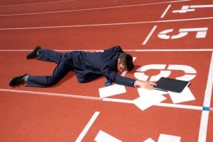 business-man-crawling-across-racetrack-finish-line