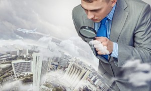 man-looking-at-city-through-magnifying-glass