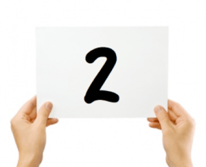 hands holding up sign with the number 2 on it