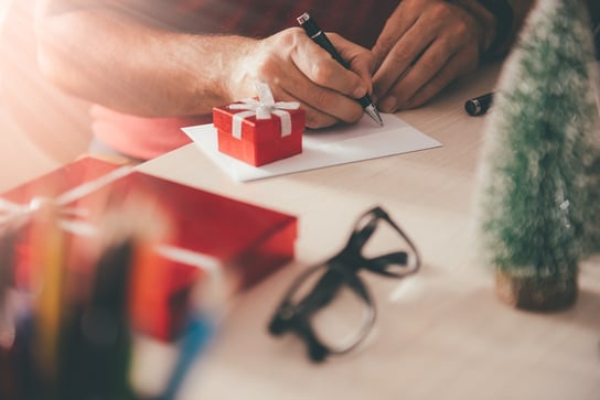 Man writes a holiday greeting card